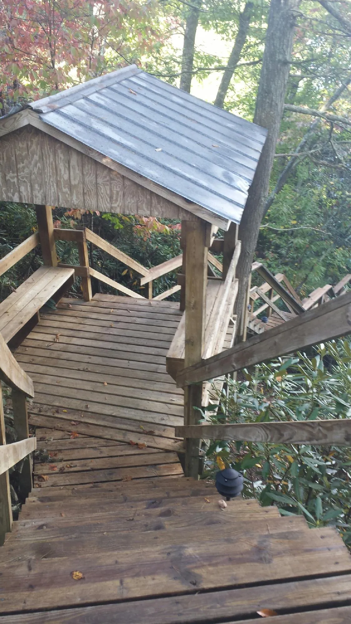 Metal roofed shelter over wooden steps on a wooded walkway — Skylight Repair & Installation work by our crew in Mckinney