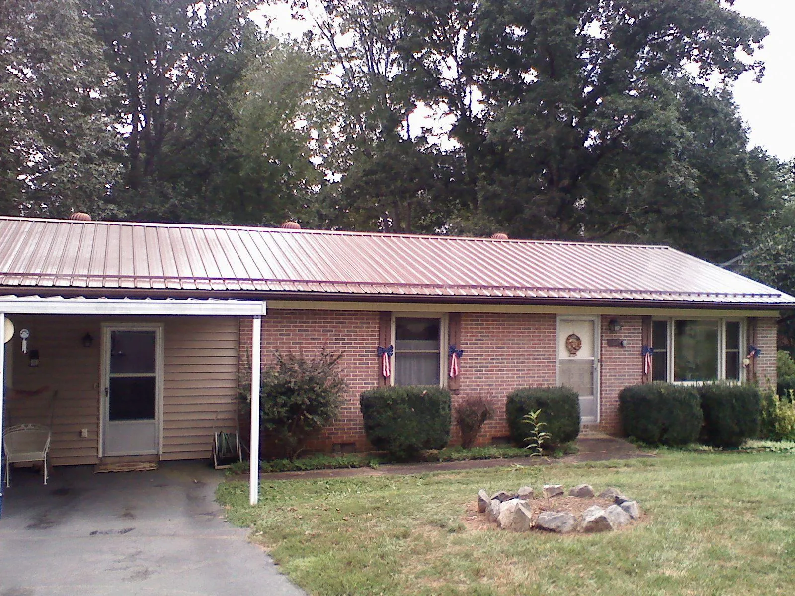 Bronze metal roof and carport on a brick ranch home — Roof Repair work by our crew in Mckinney