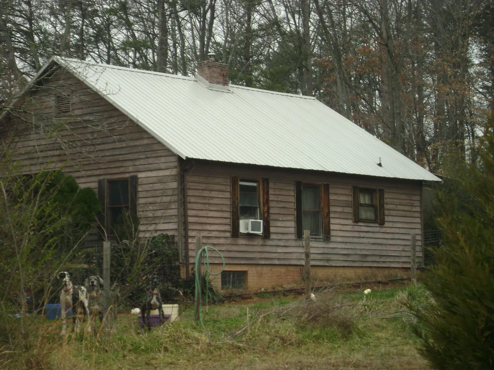 White metal roof on an old wood sided farmhouse, from a Metal Roof Installation job in Mckinney